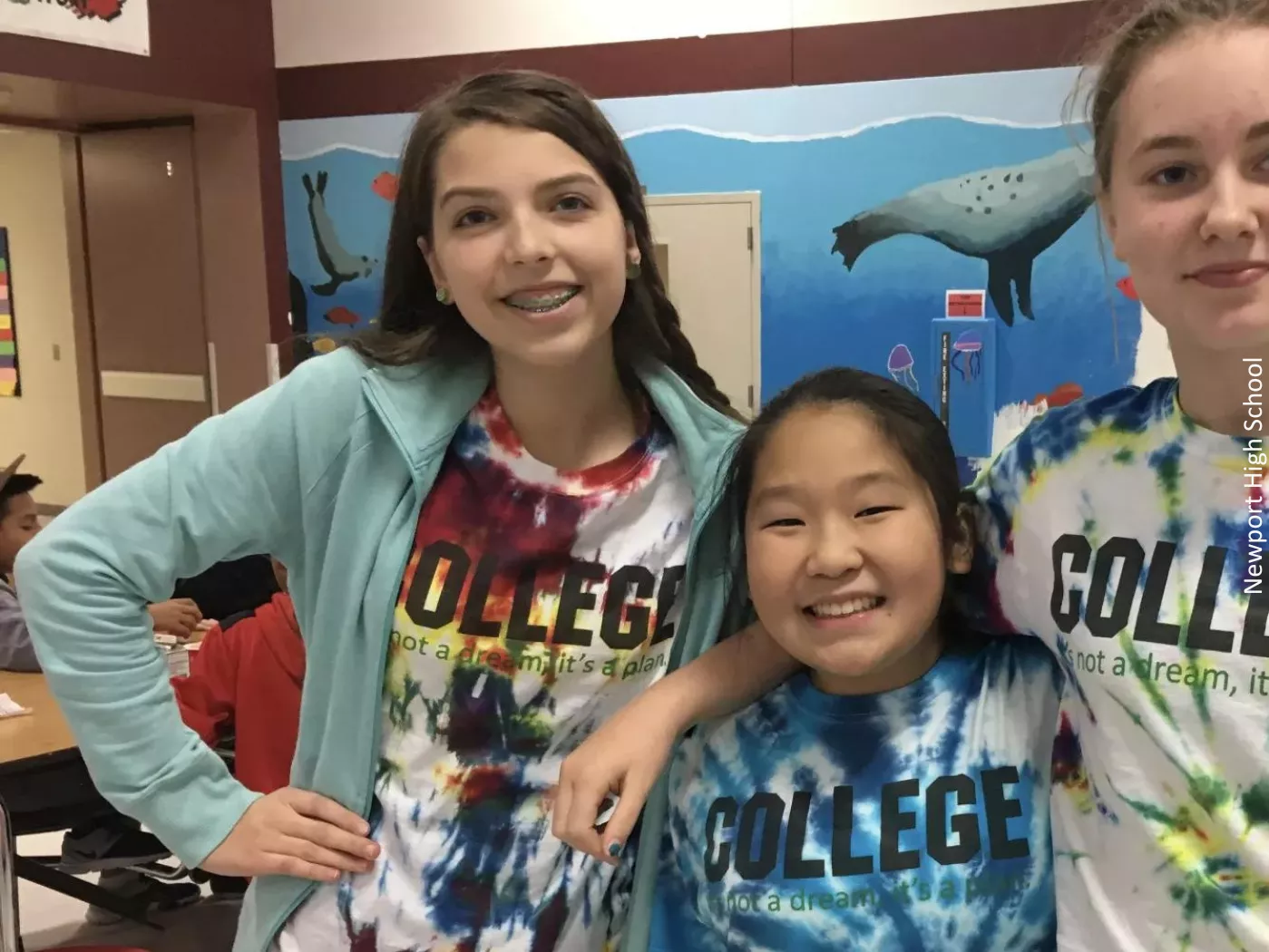 three students smiling with shirts that say College it's not a dream, it's a plan and a caption saying Newport High School