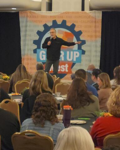 A man on stage addressing a crowd