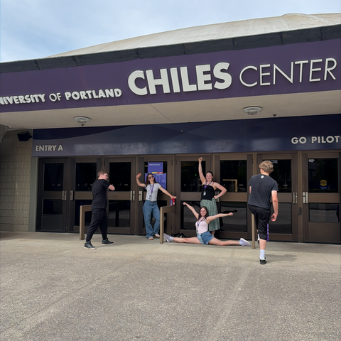 students posing in front of a building that reads "university of Portland Chiles Center"
