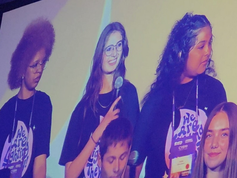 Students on stage and one holding a microphone
